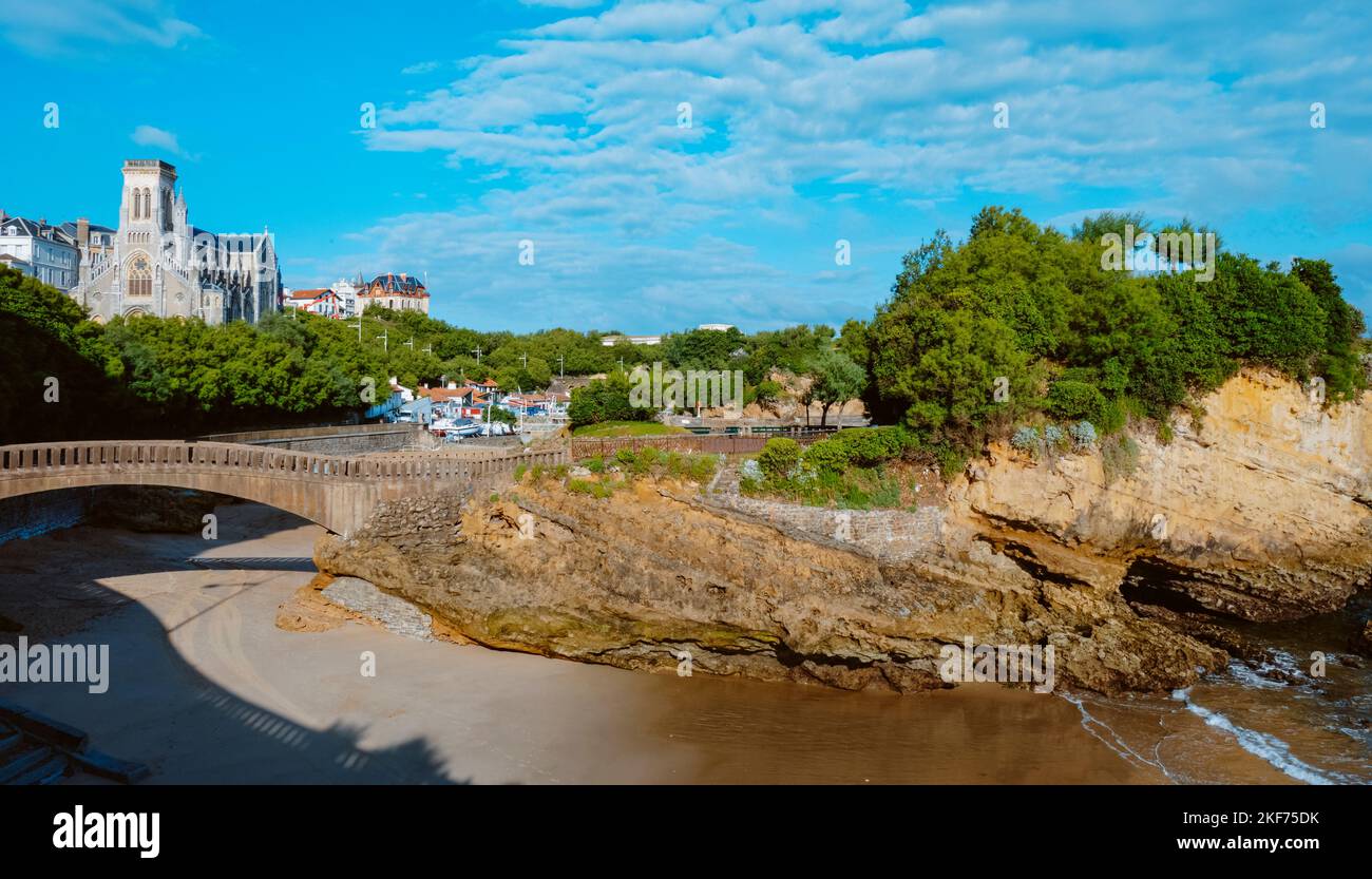 a view of the Rocher du Basta in Biarritz, France, with the Port des Pecheurs, the fishermen port, and the Sainte-Eugenie Church in the background Stock Photo