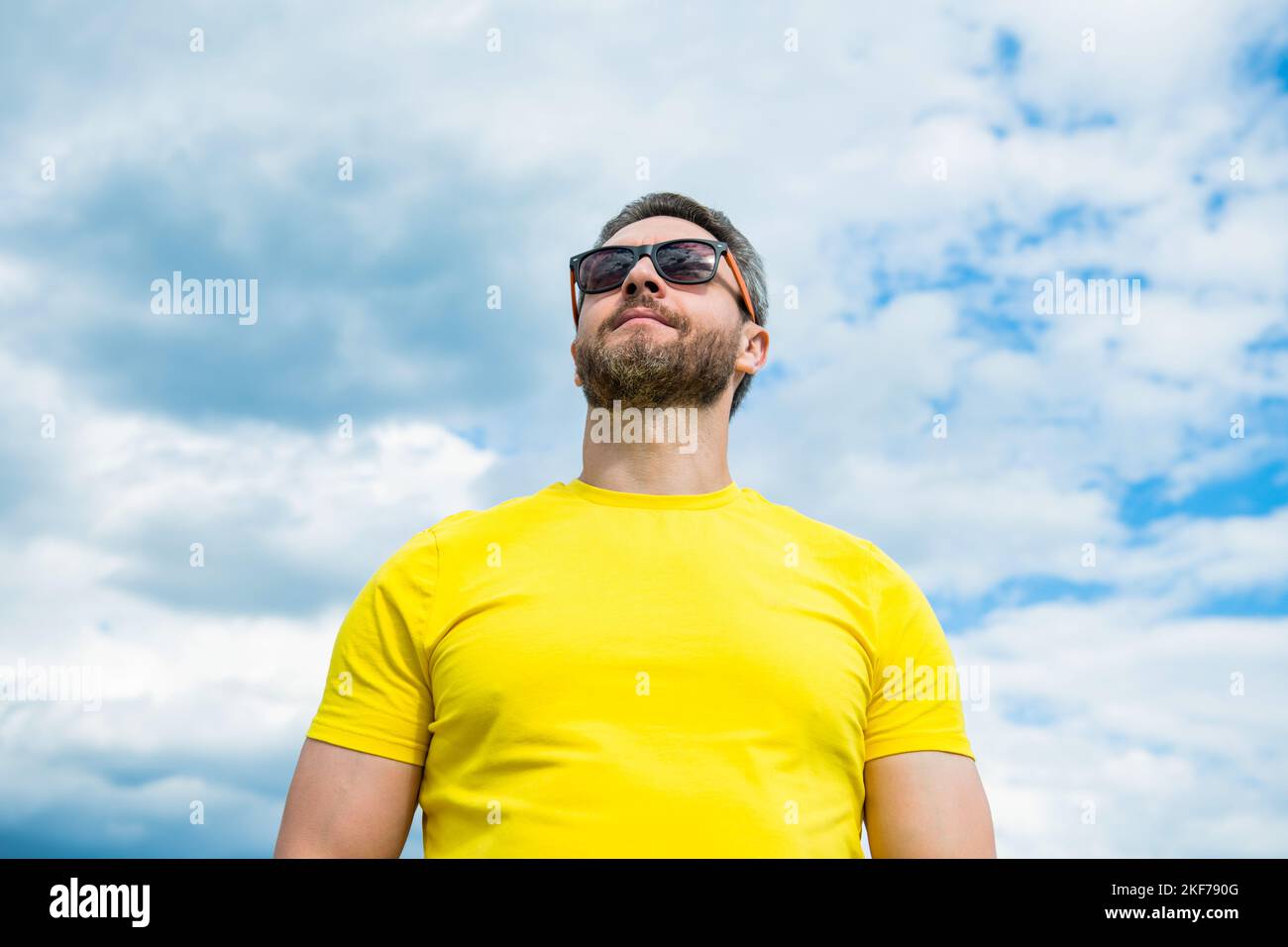 bearded man wearing yellow shirt and sunglasses outdoor on sky ...