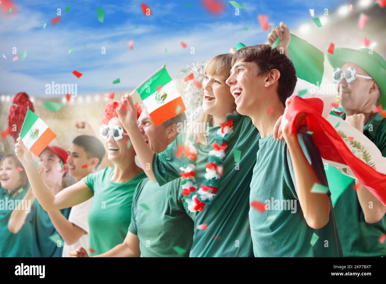 Mexico football supporter on stadium. Mexican fans on soccer pitch watching team play. Group of supporters with flag and national jersey Stock Photo