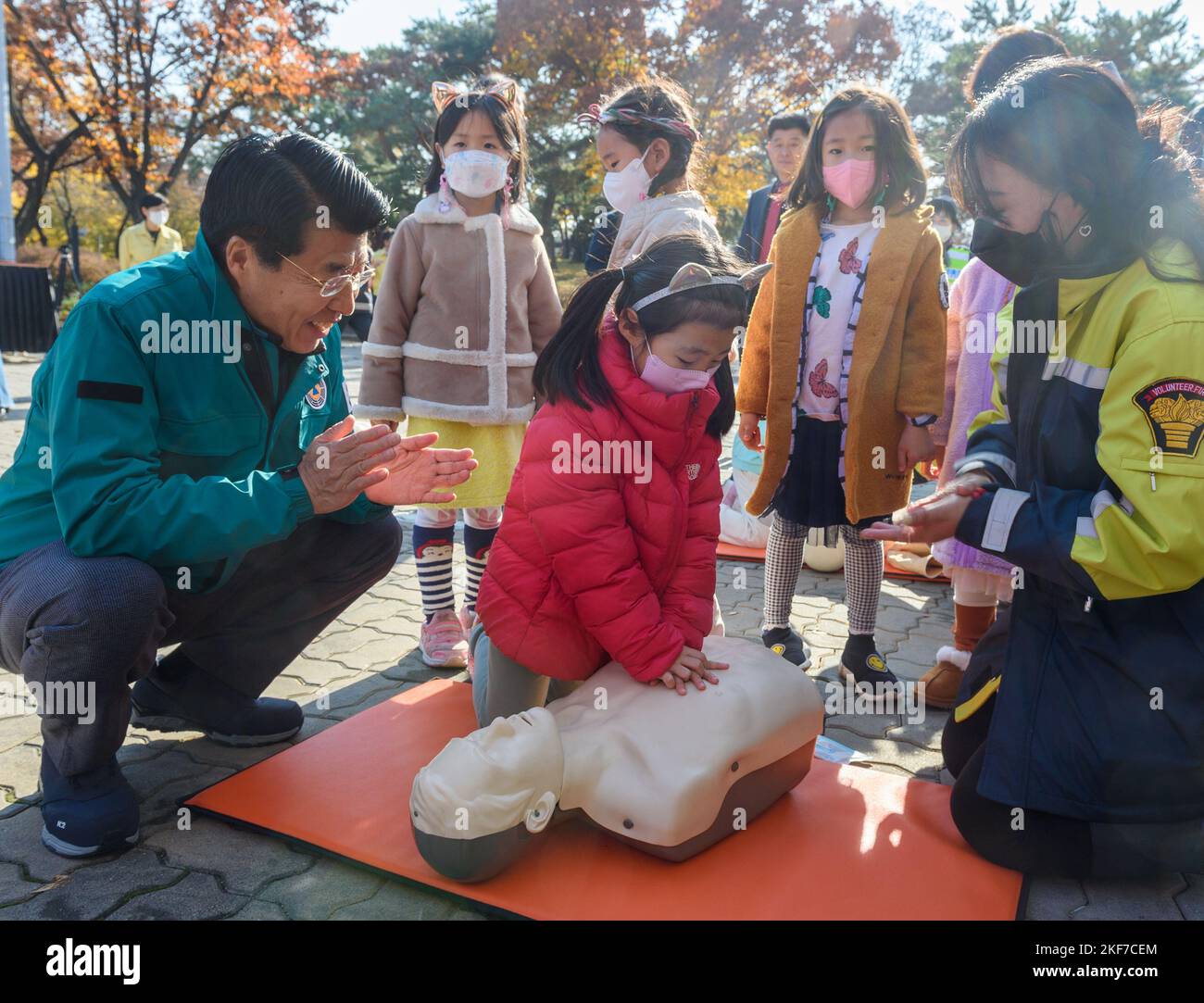 Seo Kang-suk, head of Songpa-gu District Office, encourages kindergarten students CPR training part of Safe Korea drill at a park in Seoul. The 2022 Safe Korea Training is a session to check the disaster response system nationwide from November 14 to 25 for a total of 1,433 training sessions at 300 central ministries, local governments, and public institutions. Stock Photo