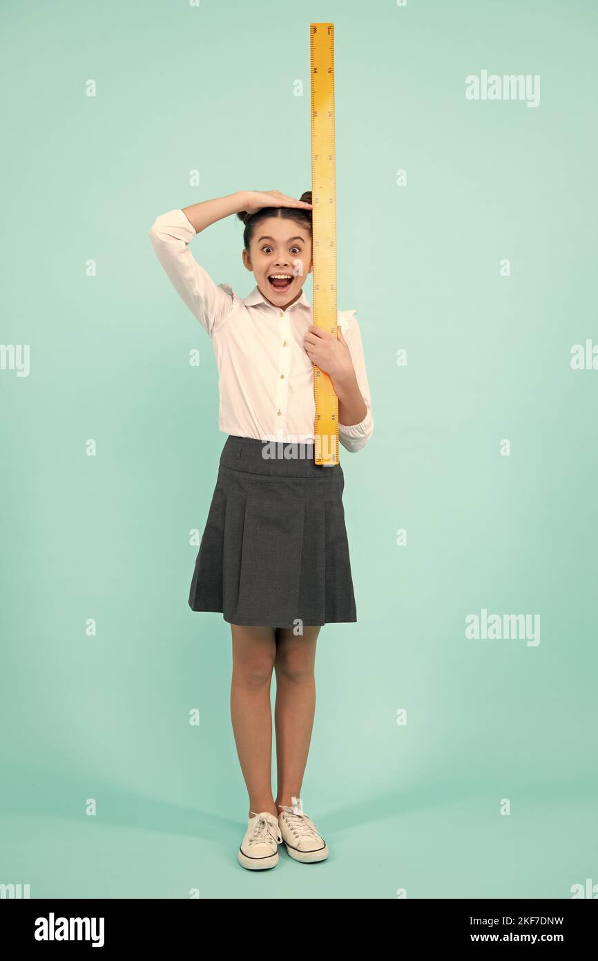 Kid height measure, growth measurement. Schoolgirl in school uniform