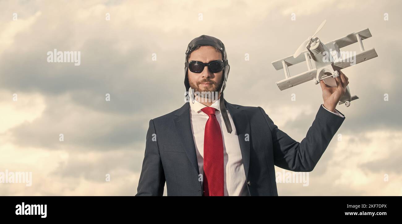 businessman in suit and pilot hat launch plane toy. aspirations Stock Photo