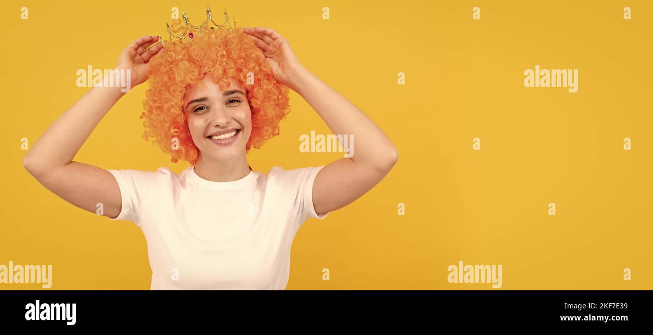 Woman isolated face portrait, banner with copy space. look what i have. birthday party goer. happy funny woman in curly wig and crown. Stock Photo