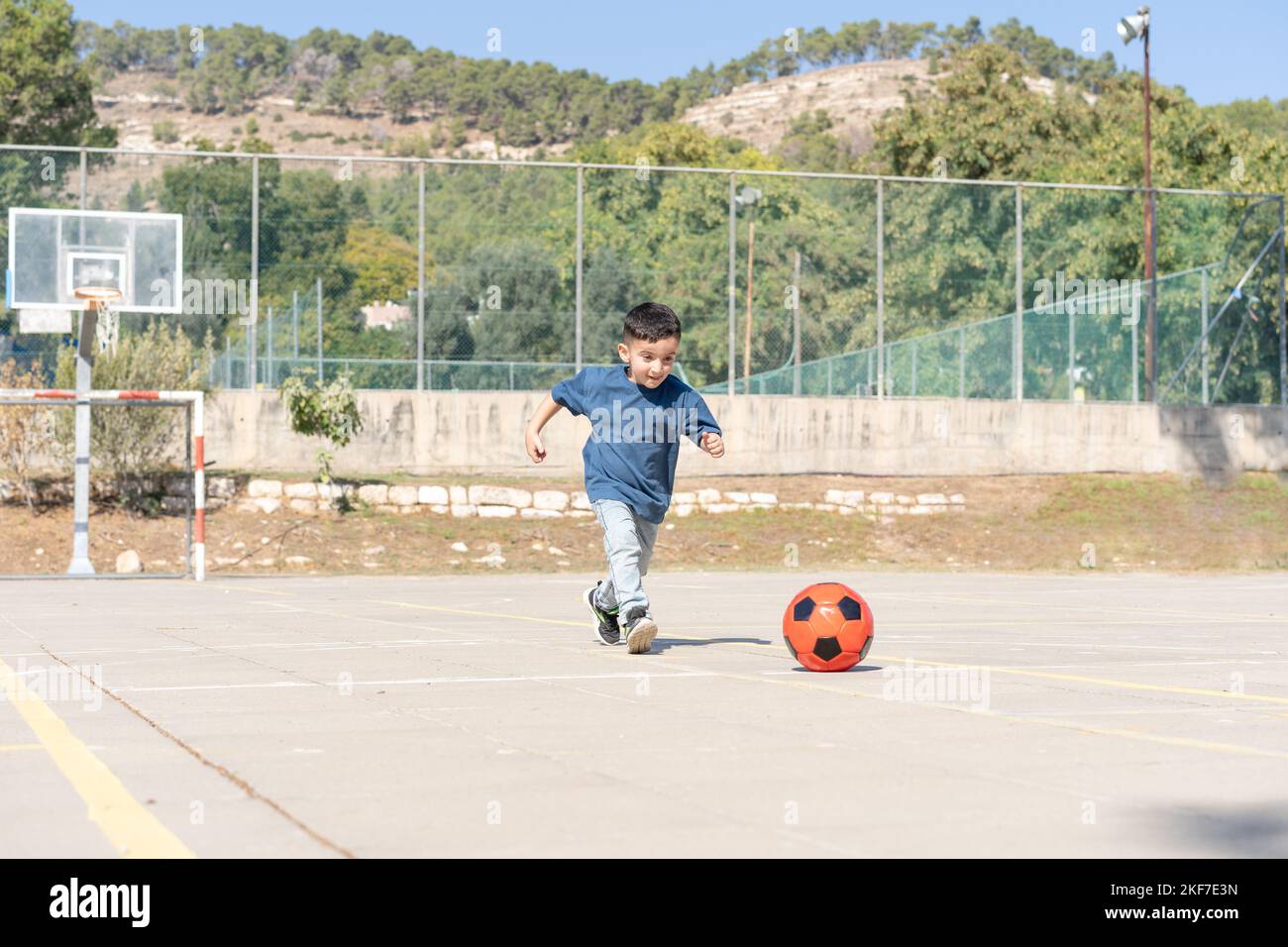 Cute Boy Running With Ball. Little Child Playing Football. Stock Photo