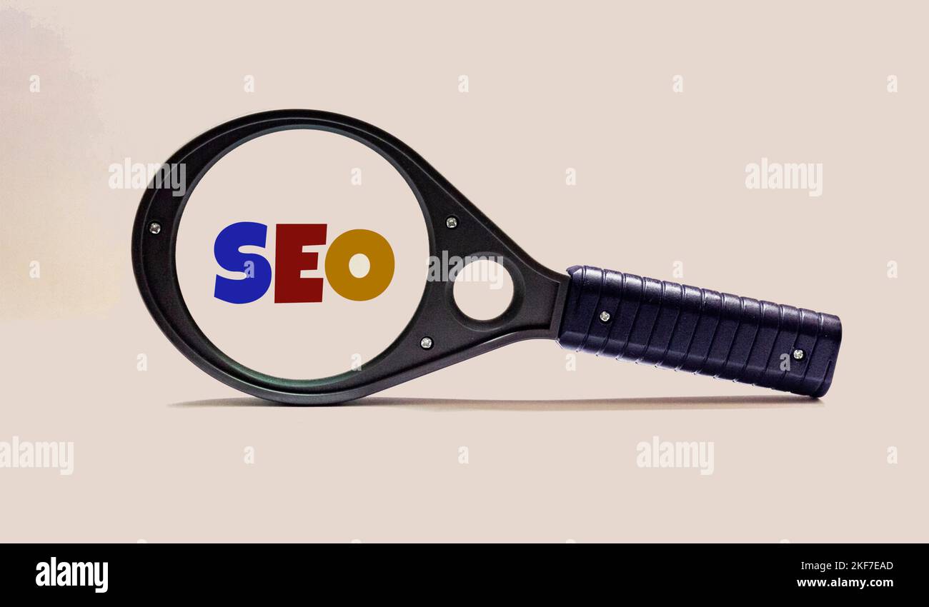 Selective focus of magnifying glass with SEO Search Engine Optimization text on white background. Stock Photo