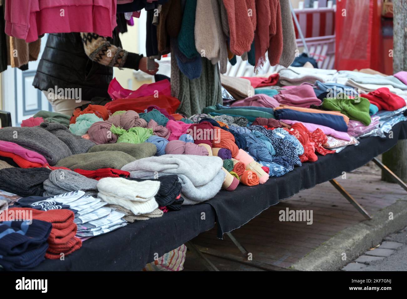 Colorful warm clothes for sale in a stall at an autumn and winter market around Christmas, selected focus Stock Photo