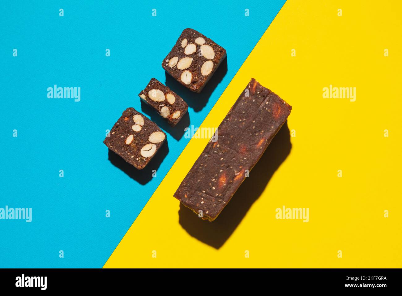 Protein date fruit candy bars fitness with nuts top view on blue yellow