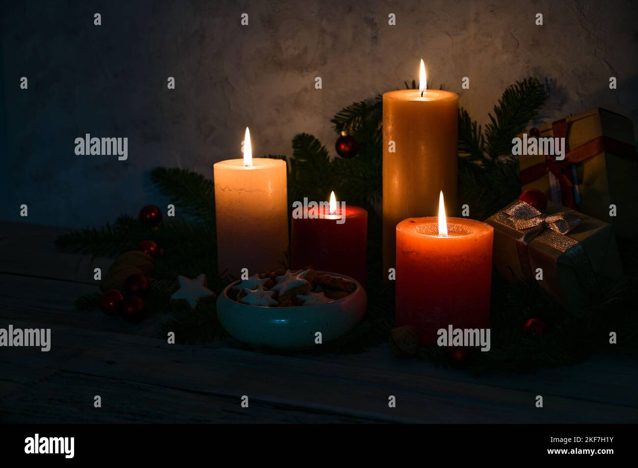 Candlelight in the dark, four advent candles, cinnamon star cookies and fir branches as decoration in the Christmas time, copy space, selected focus, Stock Photo