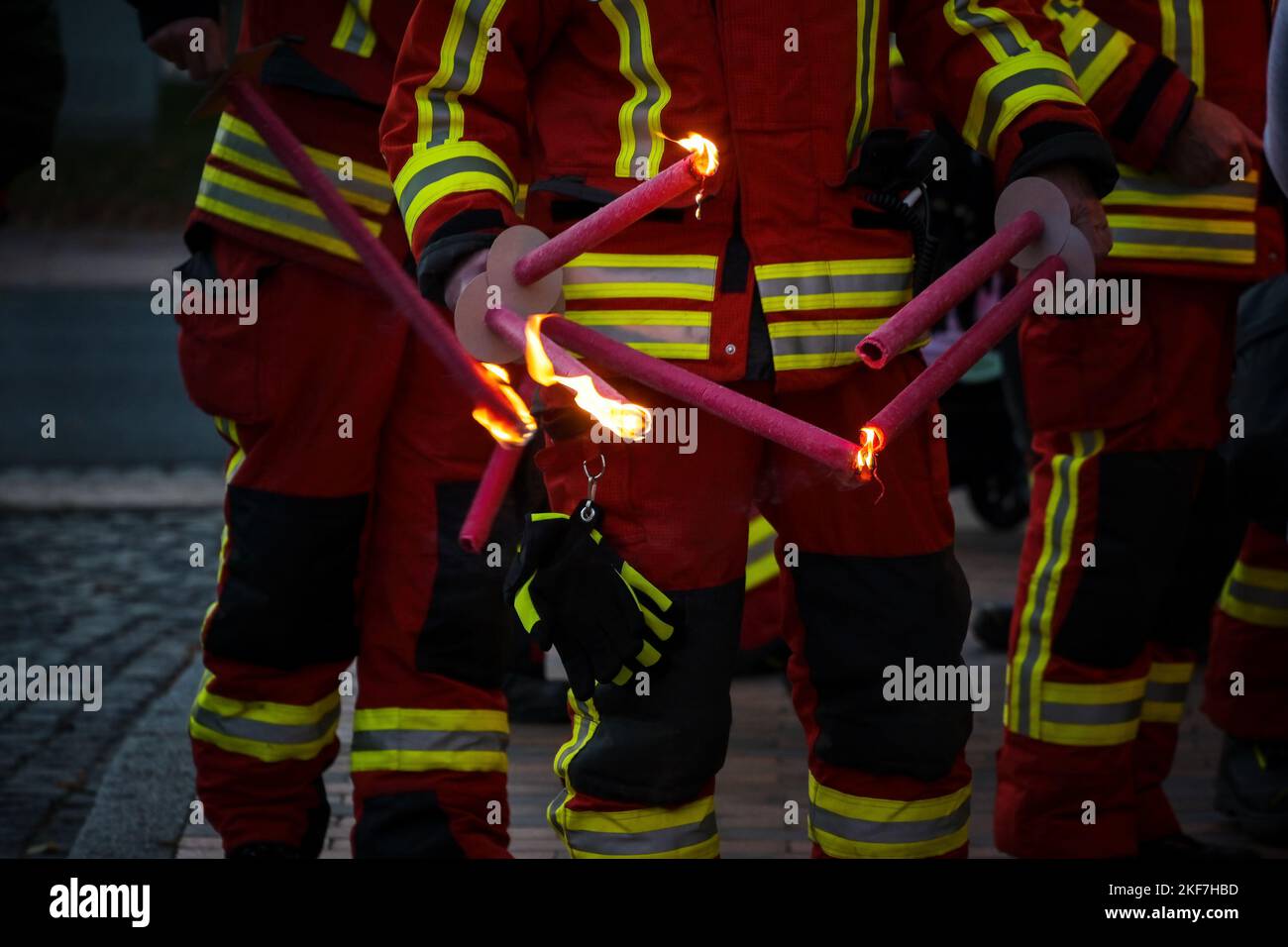 Firefighters lighting torches for a traditional procession of lights on St. Martin's Day at night, selected focus, narrow depth of field Stock Photo