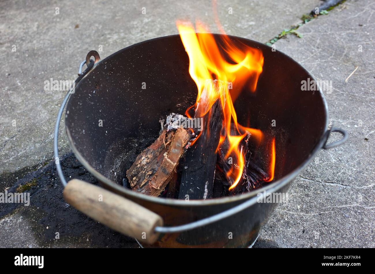 Do it yourself backyard BBQ grill in  a bucket with sausages and potatoes Stock Photo