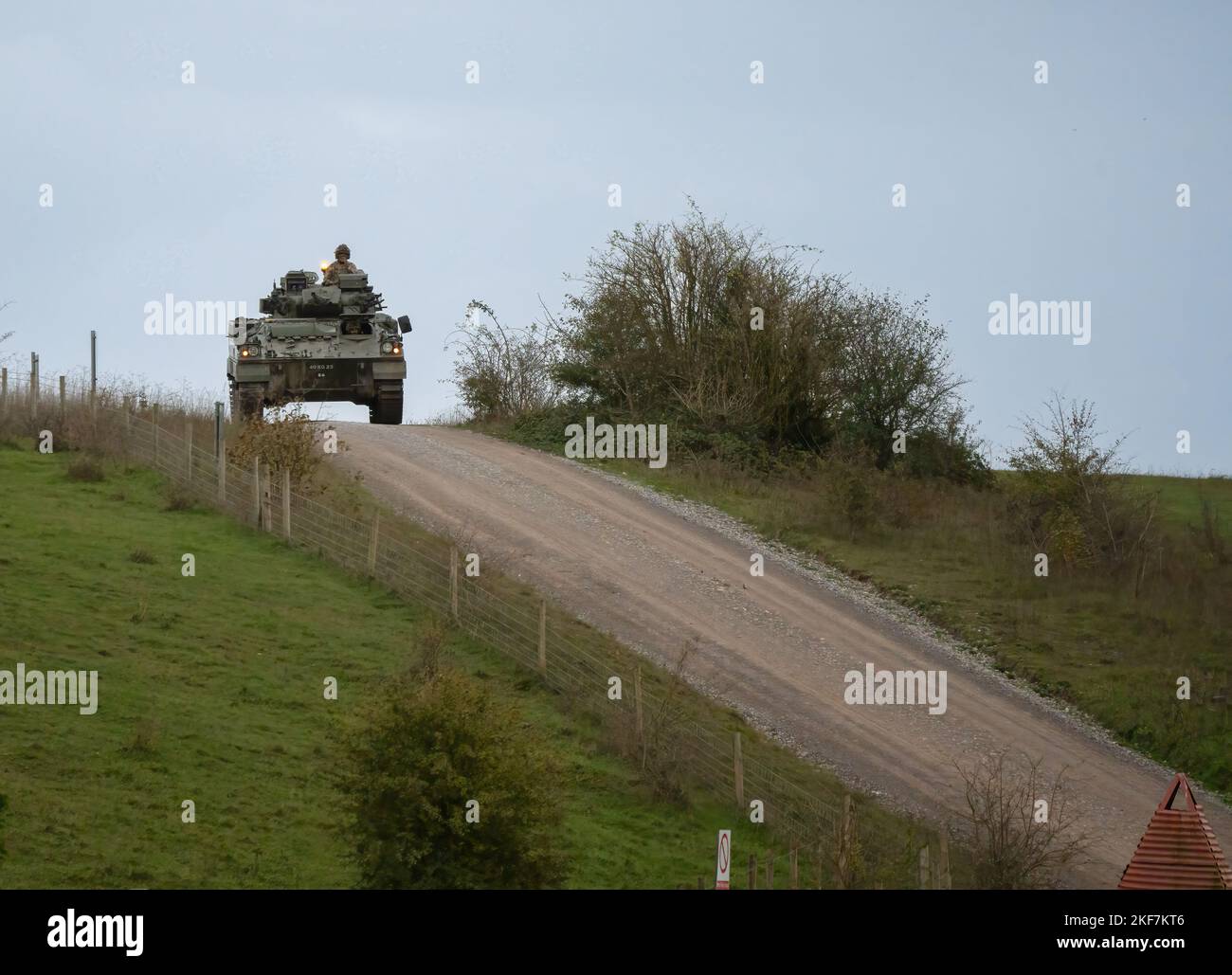 British army Warrior FV510 Fighting Vehicle in action driving on a mud track on a military exercise, Wiltshire UK Stock Photo