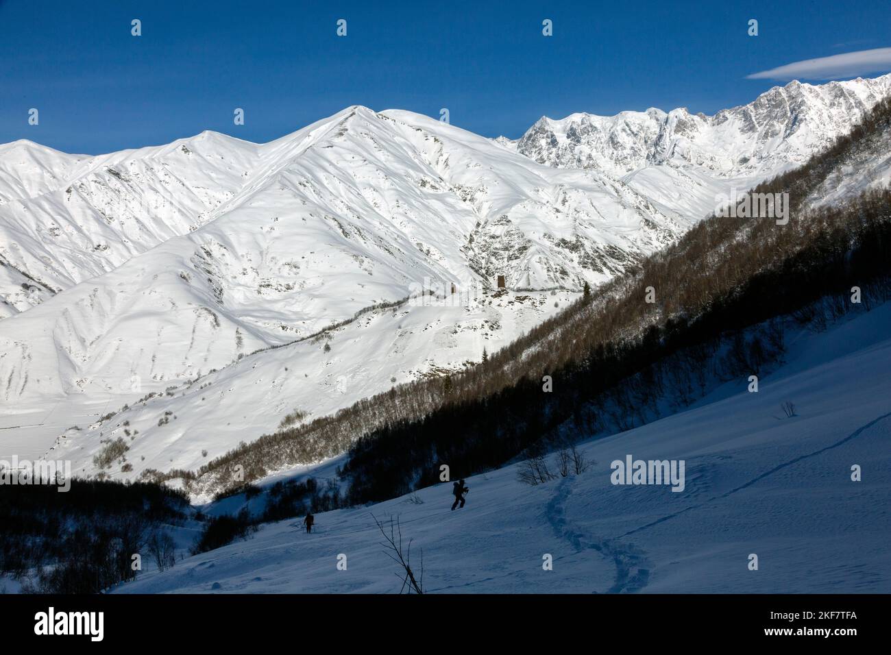 A team of freerider skiers climbs against the background of snowy ridges of the Caucasus Mountains, Svaneti, Georgia, backcountry Stock Photo