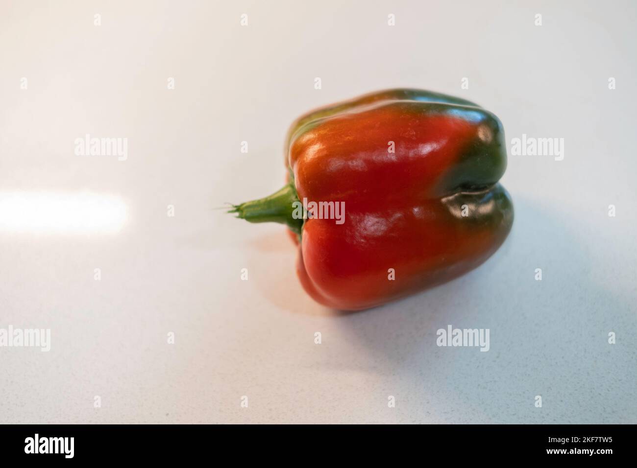 A single red bell pepper, Capsicum annuum, on a white background. Stock Photo