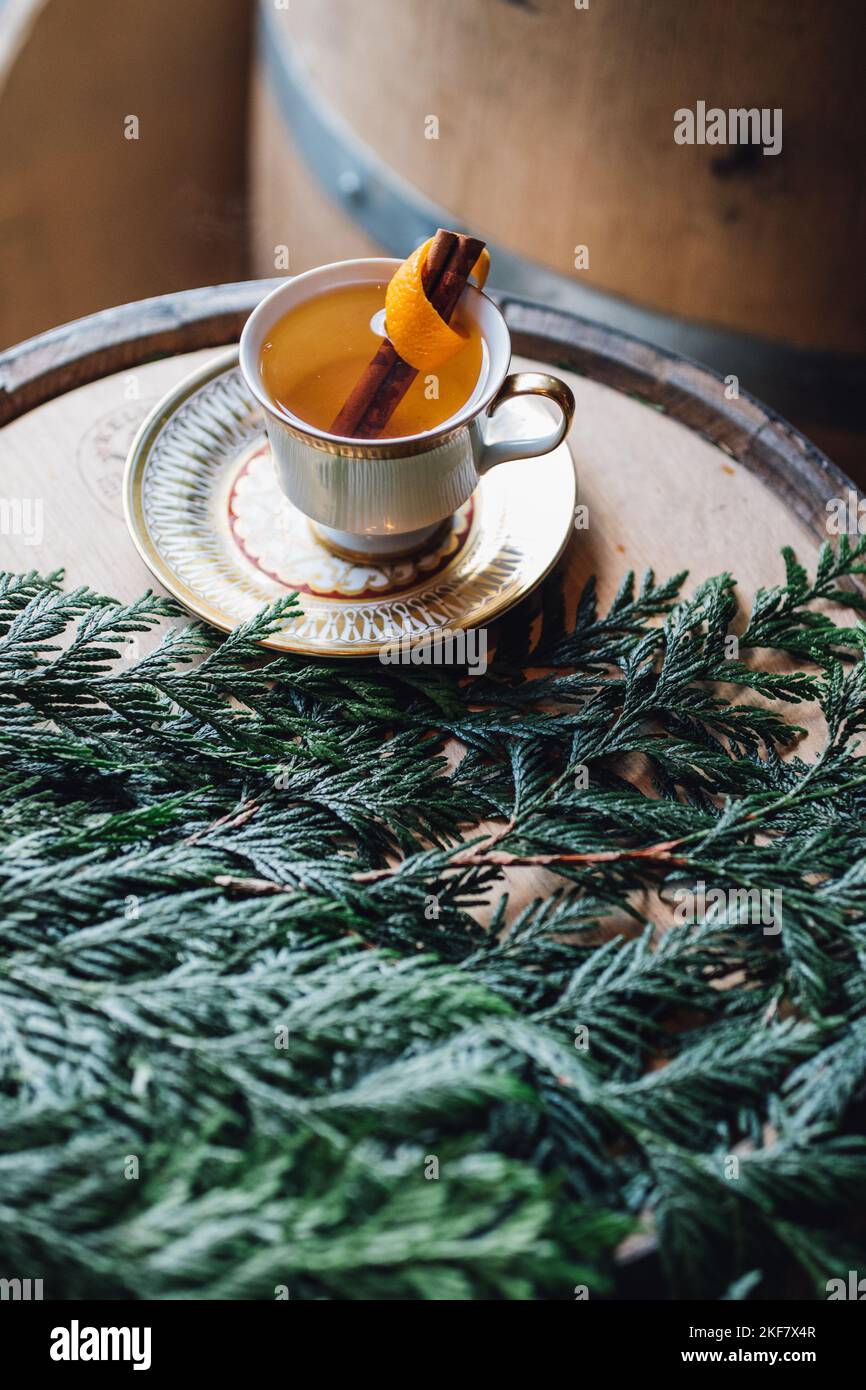 hot toddy in a teacup on bourbon barrel with holiday greenery Stock Photo