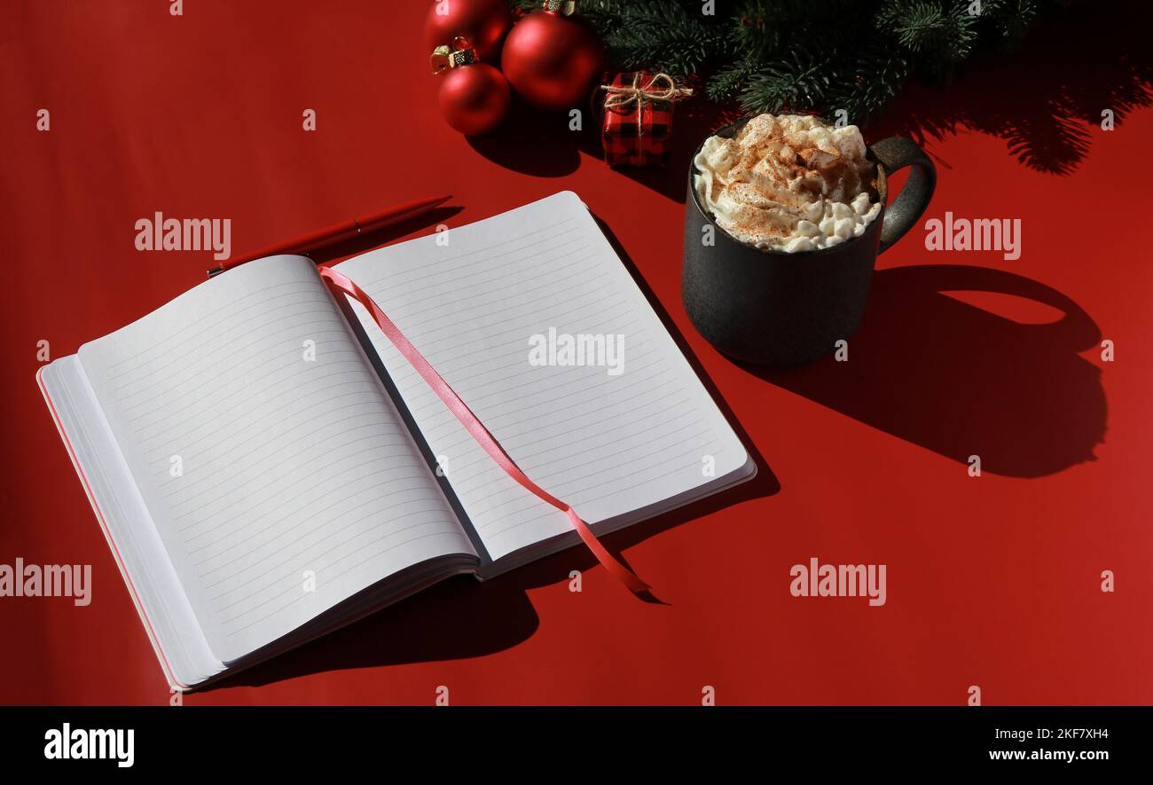 red Christmas composition with hot chocolate and note book for wish list Stock Photo