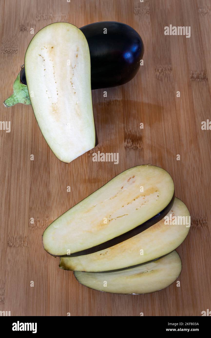 Solanum melongena  or aubergine and aubergine slices on a wooden table Stock Photo