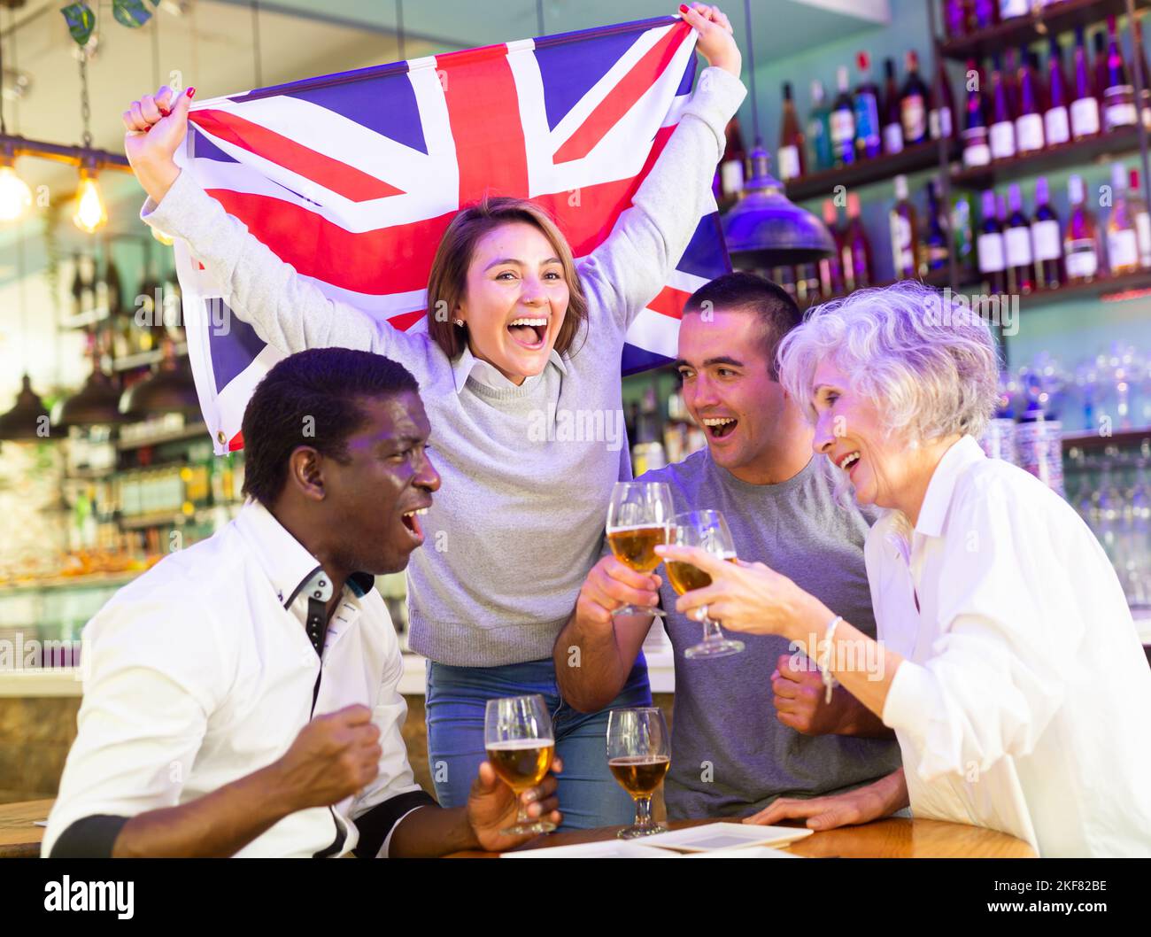Happy sport fans holding flag of the Great Britain, celebrating victory