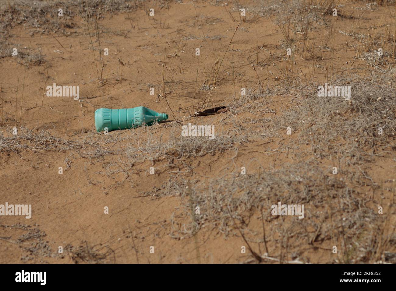 Old plastic bottle is on the beach leave by tourist. The problem of microplastics in the environment. Stock Photo