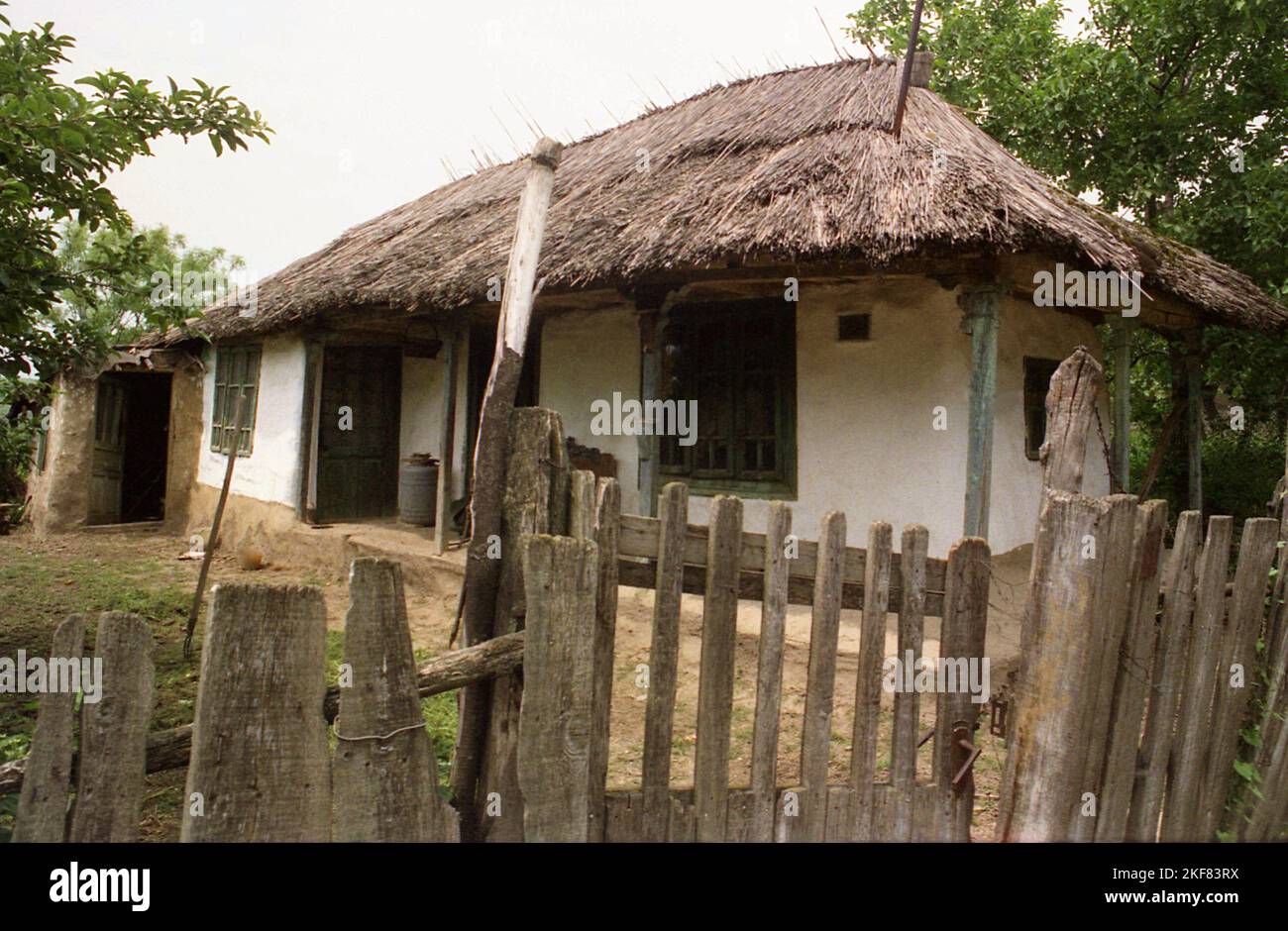 Simple traditional mud house with thatched roof in Snagov, Romania, approx. 2000. Stock Photo