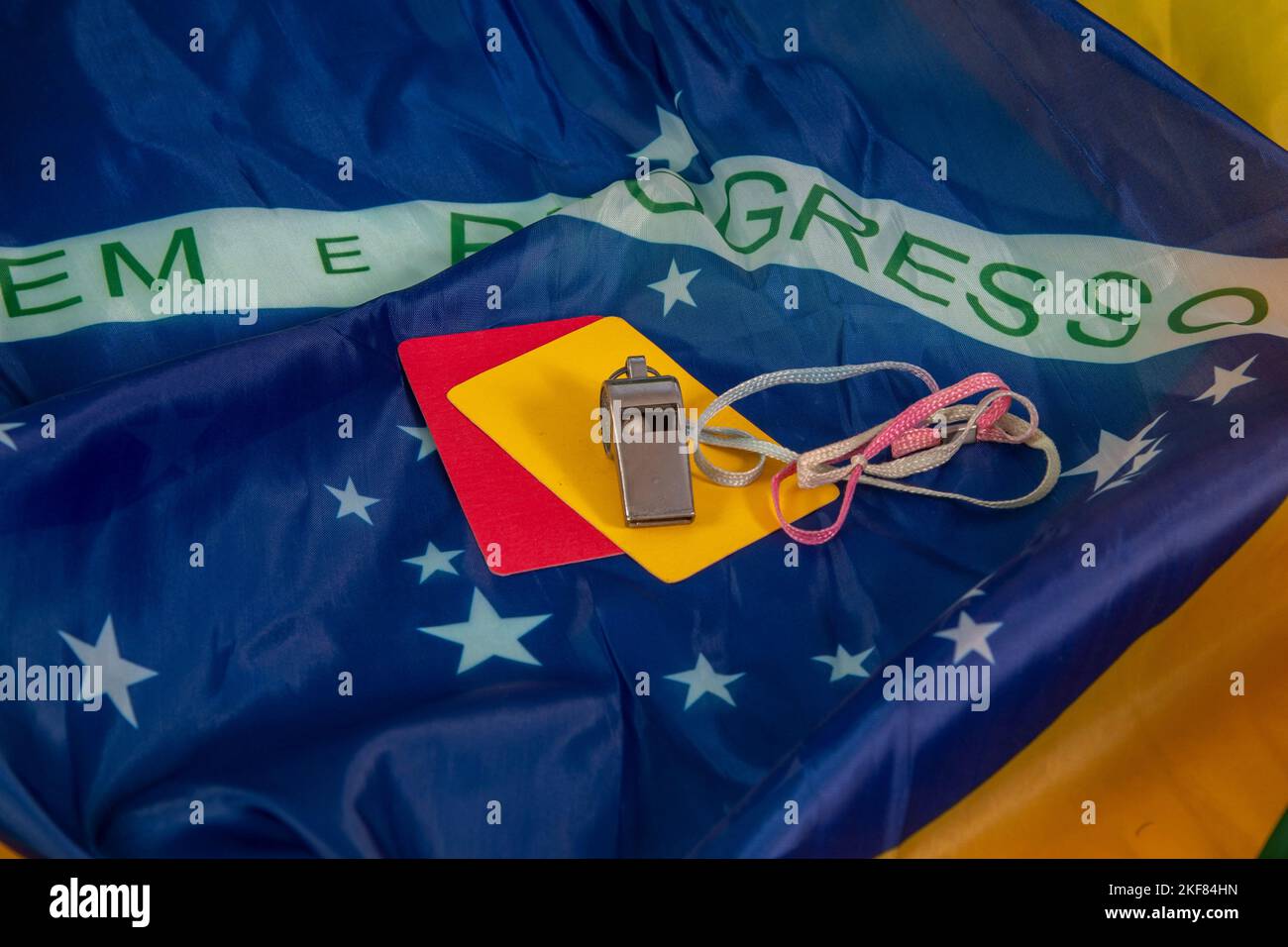 flag of brazil in wave with yellow and red soccer card and a referee whistle Stock Photo