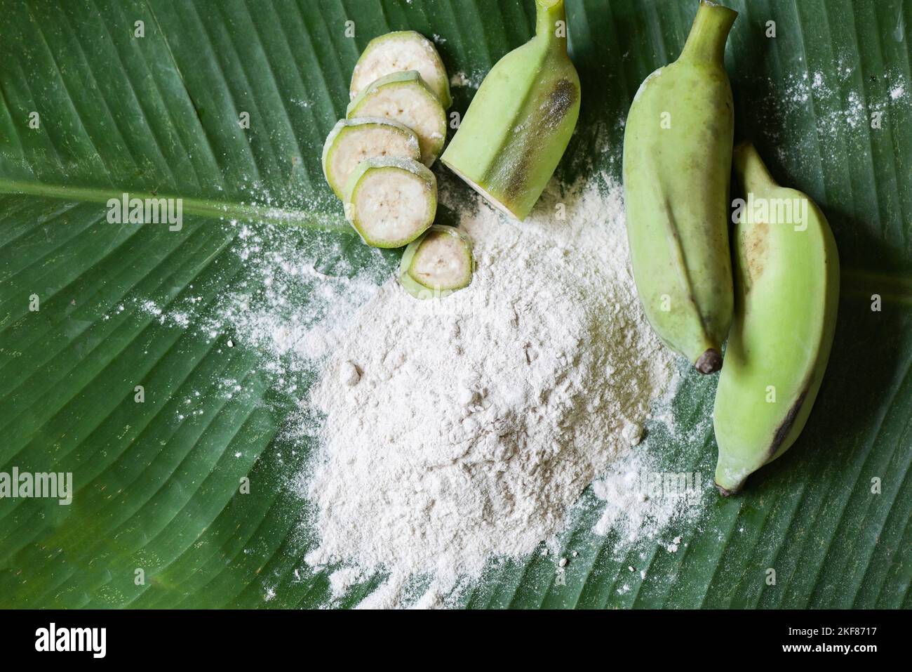 banana powder on wooden bowl and raw banana banana fruit on leaf