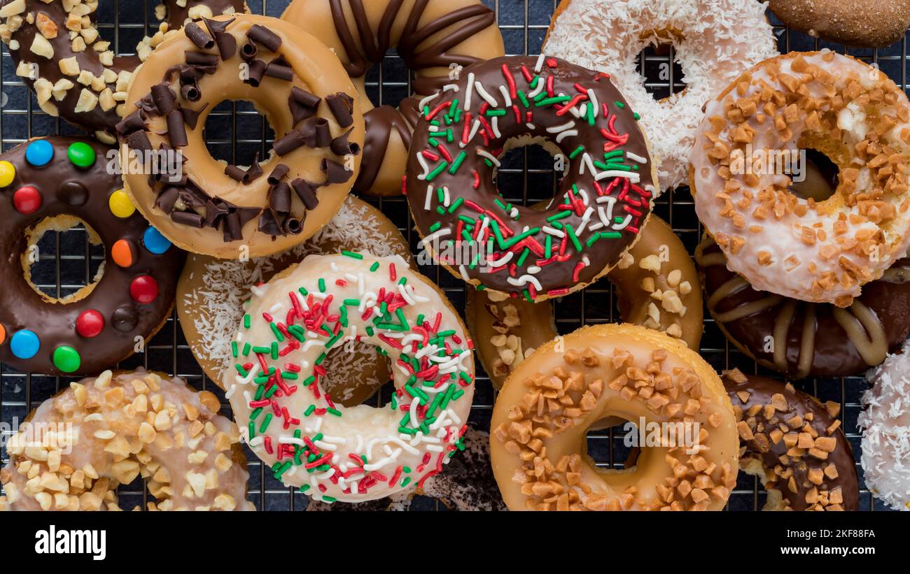 Narrow view of a pile of homemade donuts with various glazes and toppings. Stock Photo
