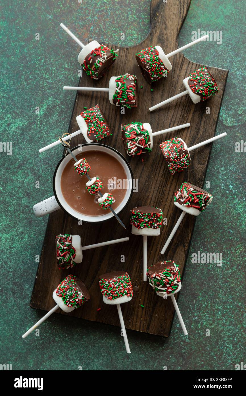 Chocolate dipped marshmallows covered in sprinkles, served with hot