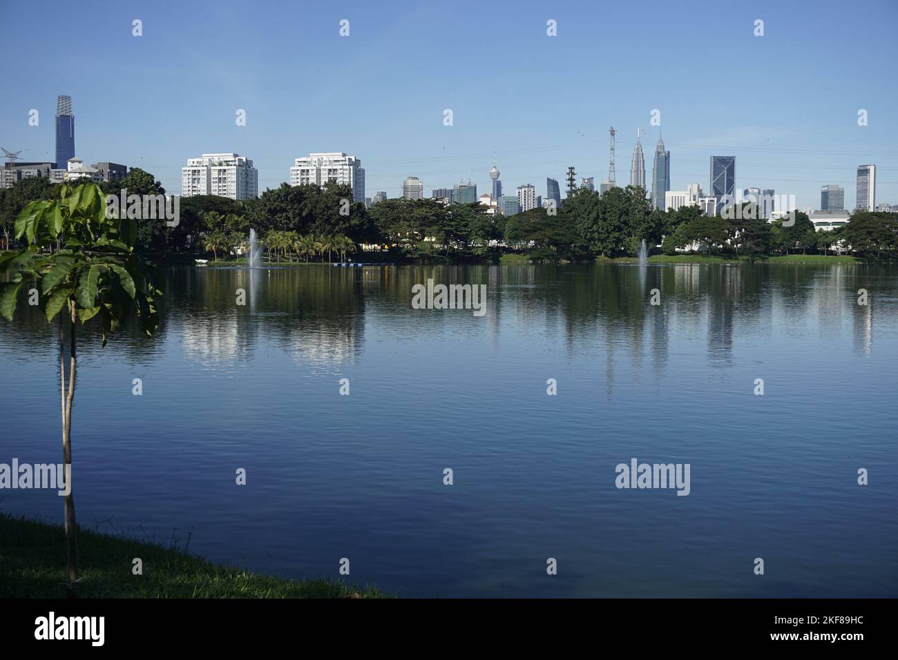 Ampang Hilir lake with view of Kuala Lumpur skyline Stock Photo