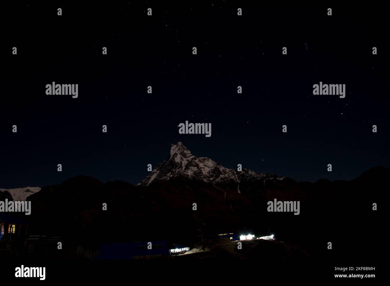 Mount Machhapuchhra (Fish Tail 6993 meters) in Himalaya mountains lit by moon. Starry sky above it Stock Photo