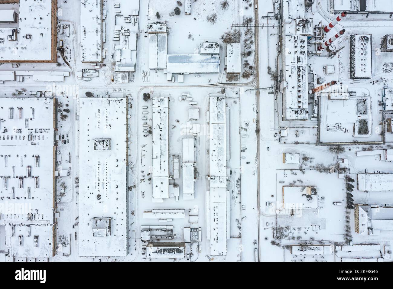 urban industrial area with manufacturing buildings, warehouses and thermal power plant at winter time. aerial top view. Stock Photo