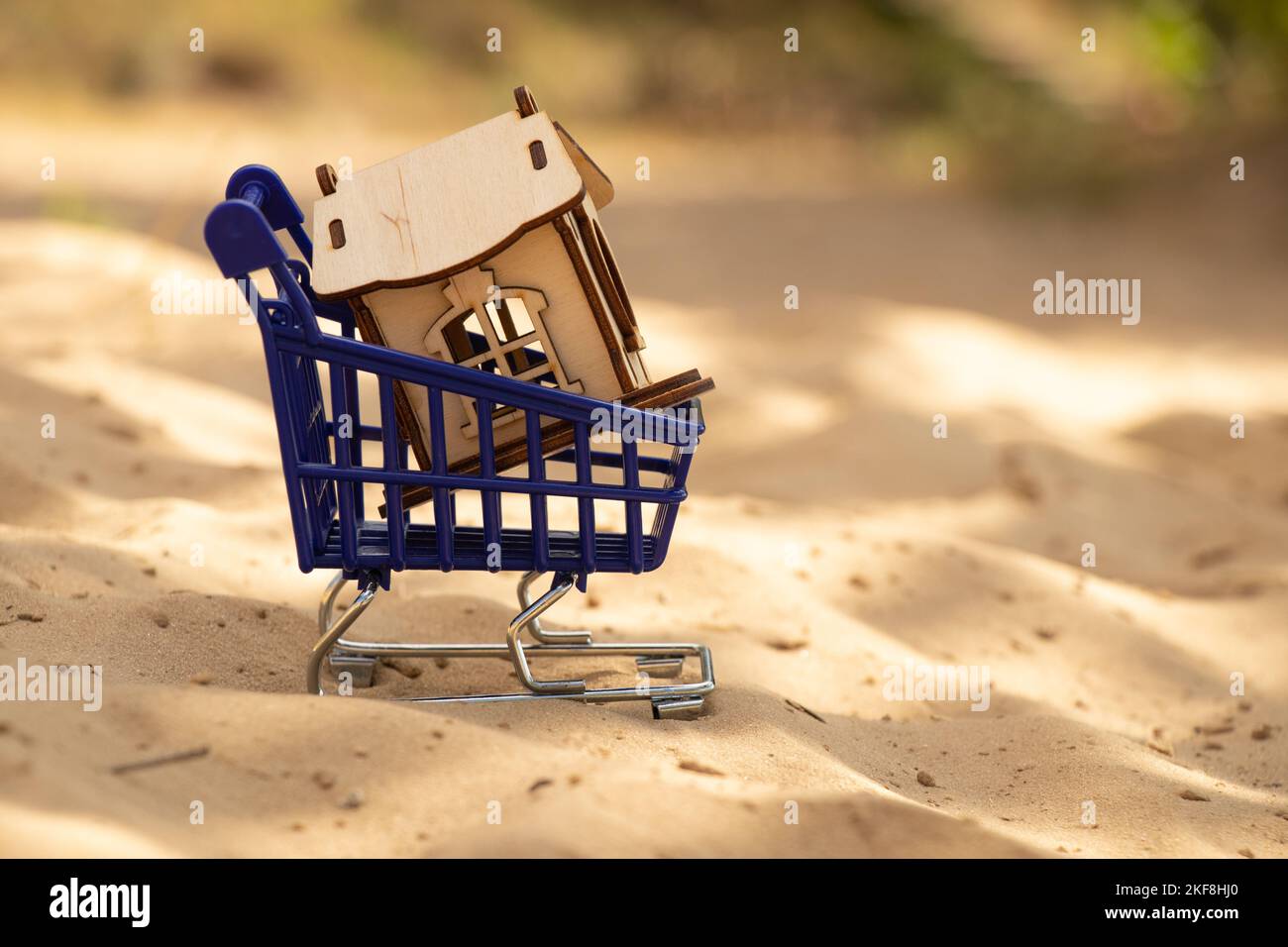 small wooden house and blue trolley with supermarket on the sand Stock Photo