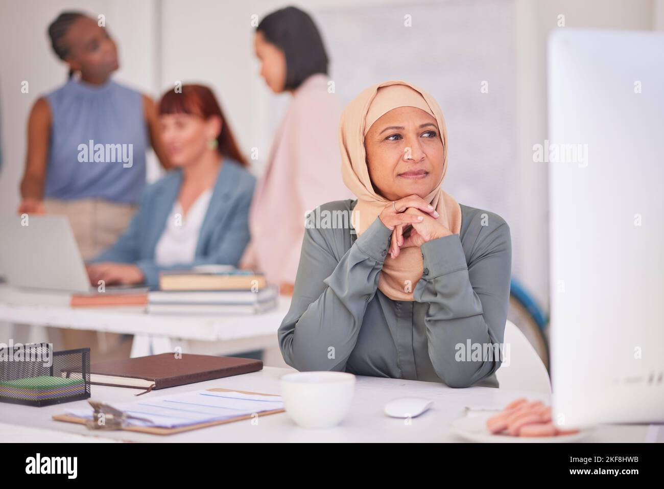 Thinking, muslim and business woman on computer, planning, question and strategy ideas, mindset and opportunity at office desk. Mature manager, hijab Stock Photo