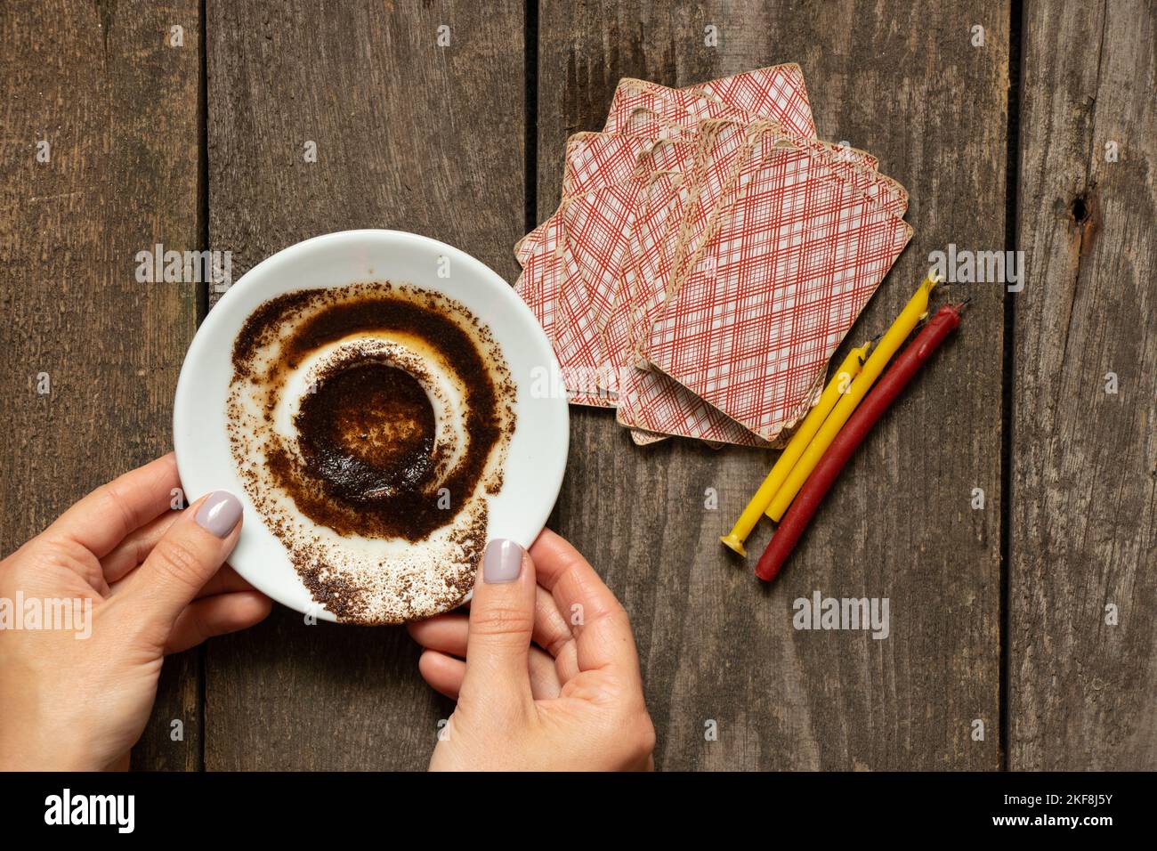 coffee grounds in the hands of a fortune teller and cards and candles on the table, fortune