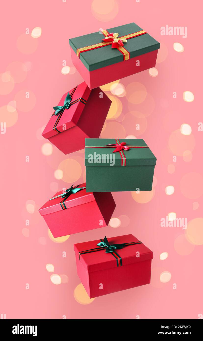 Flying Christmas gift boxes on pink background Stock Photo