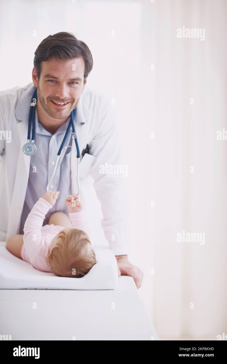 He loves working with his tiny patients. Portrait of a male doctor ...