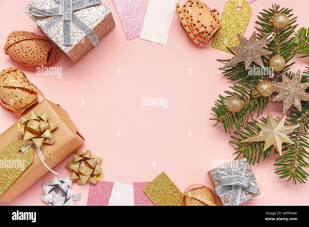 Frame made of Christmas gifts, decorations and fir branch on pink ...