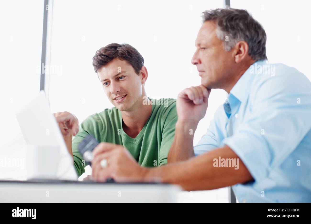 Gaining valuable work experience. A mature executive looking over some work on a laptop with a younger colleague. Stock Photo