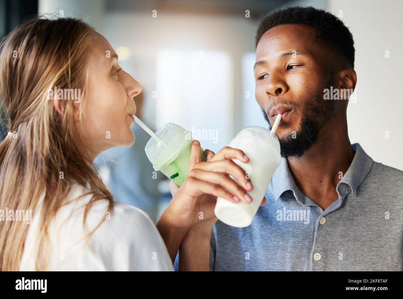 Restaurant, date and couple drinking a milkshake together while at a romantic summer adventure. Happy, love and interracial man and woman enjoying a Stock Photo