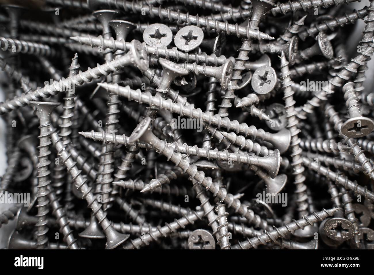 Black long self-tapping screws close-up in a box. wood screws Stock Photo