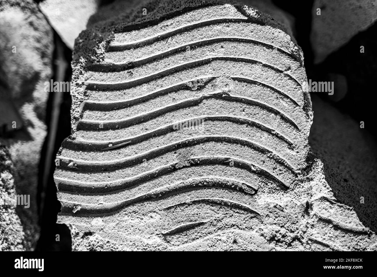 A layer of glue on a dismantled aerated concrete block close-up. The technique of applying mortar to the surface of a brick when laying a wall. Unifor Stock Photo