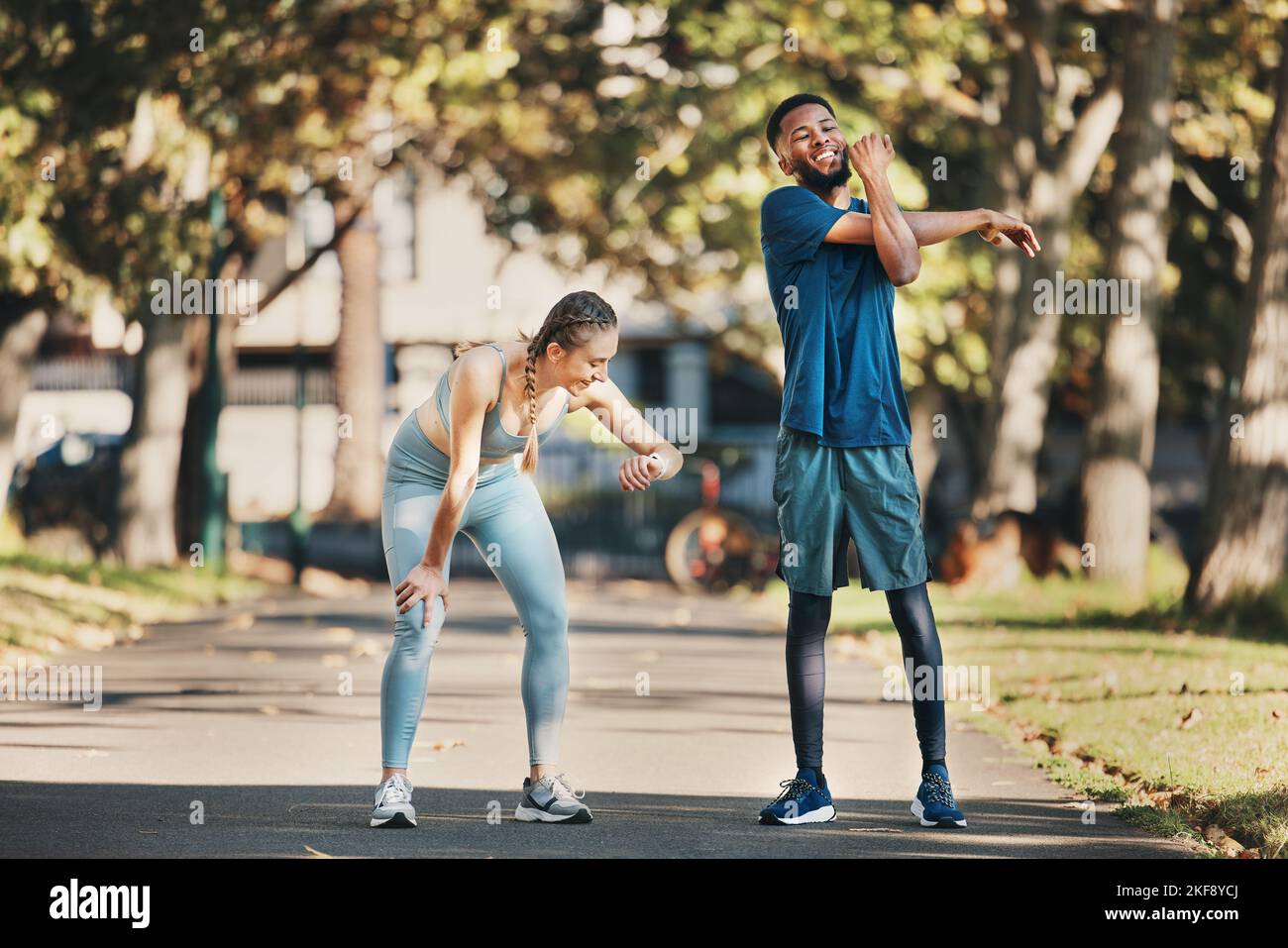 Fitness, stretching and couple rest in park after running, exercise and workout together in city. Health, wellness and interracial couple and doing Stock Photo