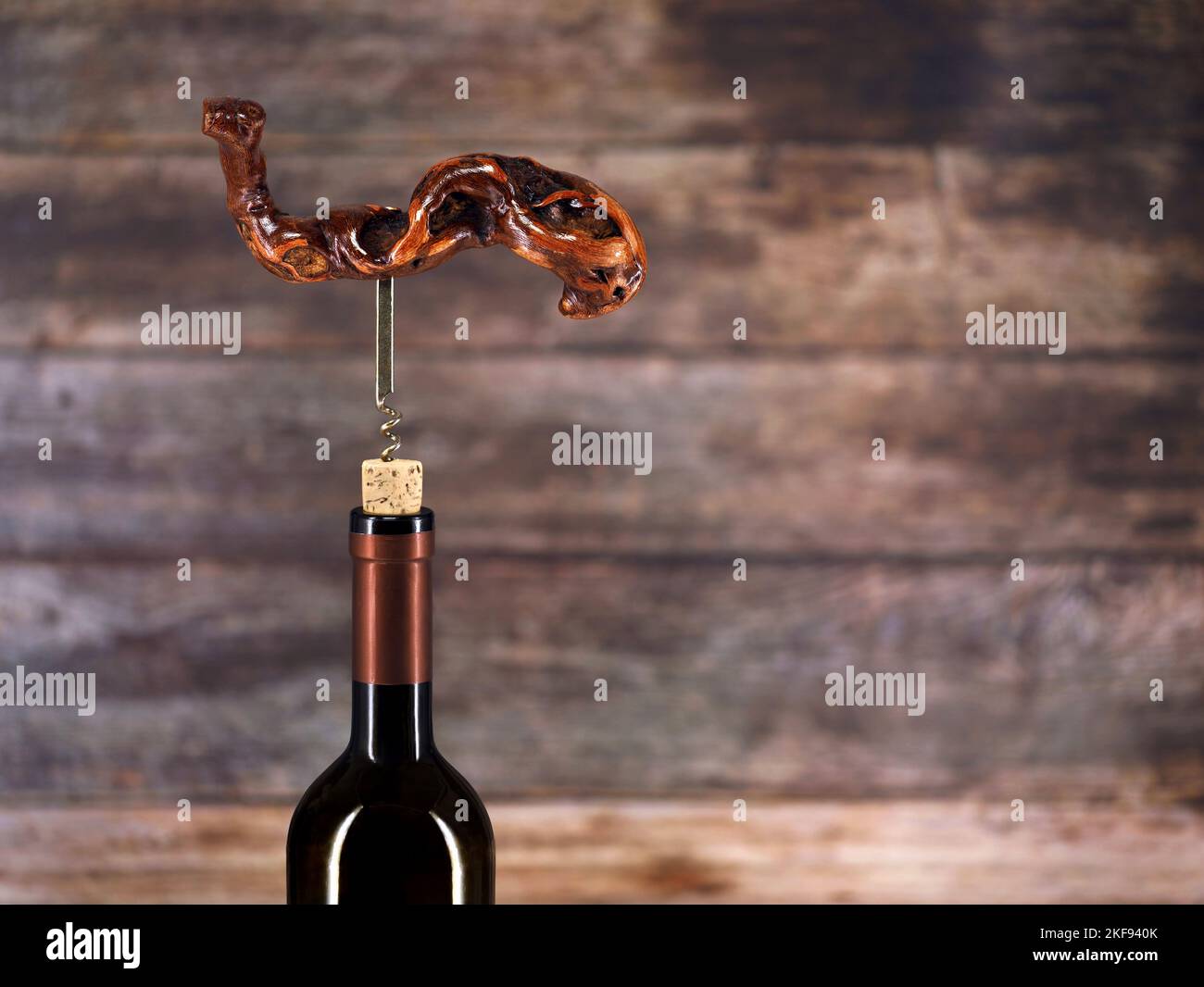 Bottle of wine with old vintage wooden corkscrew on wooden background with copy space Stock Photo