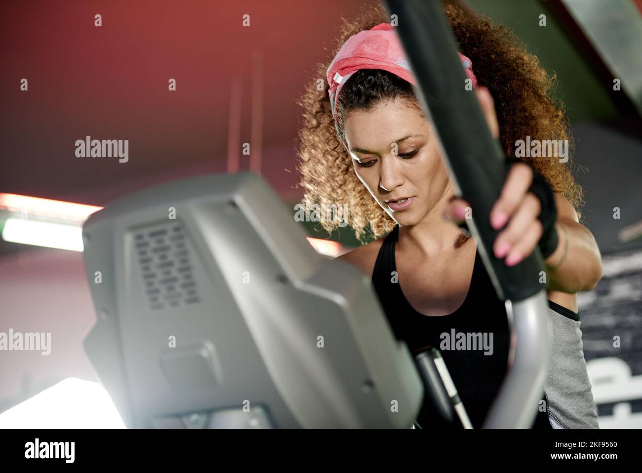 Stepping up the pace. a young woman working out with a stepping machine at the gym. Stock Photo