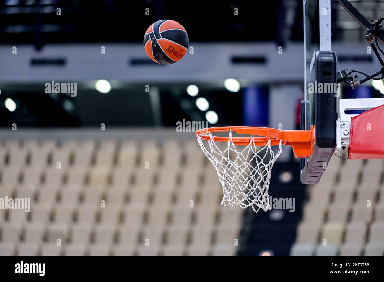 Basket ball entering the net in a basketball court with empty seats ...