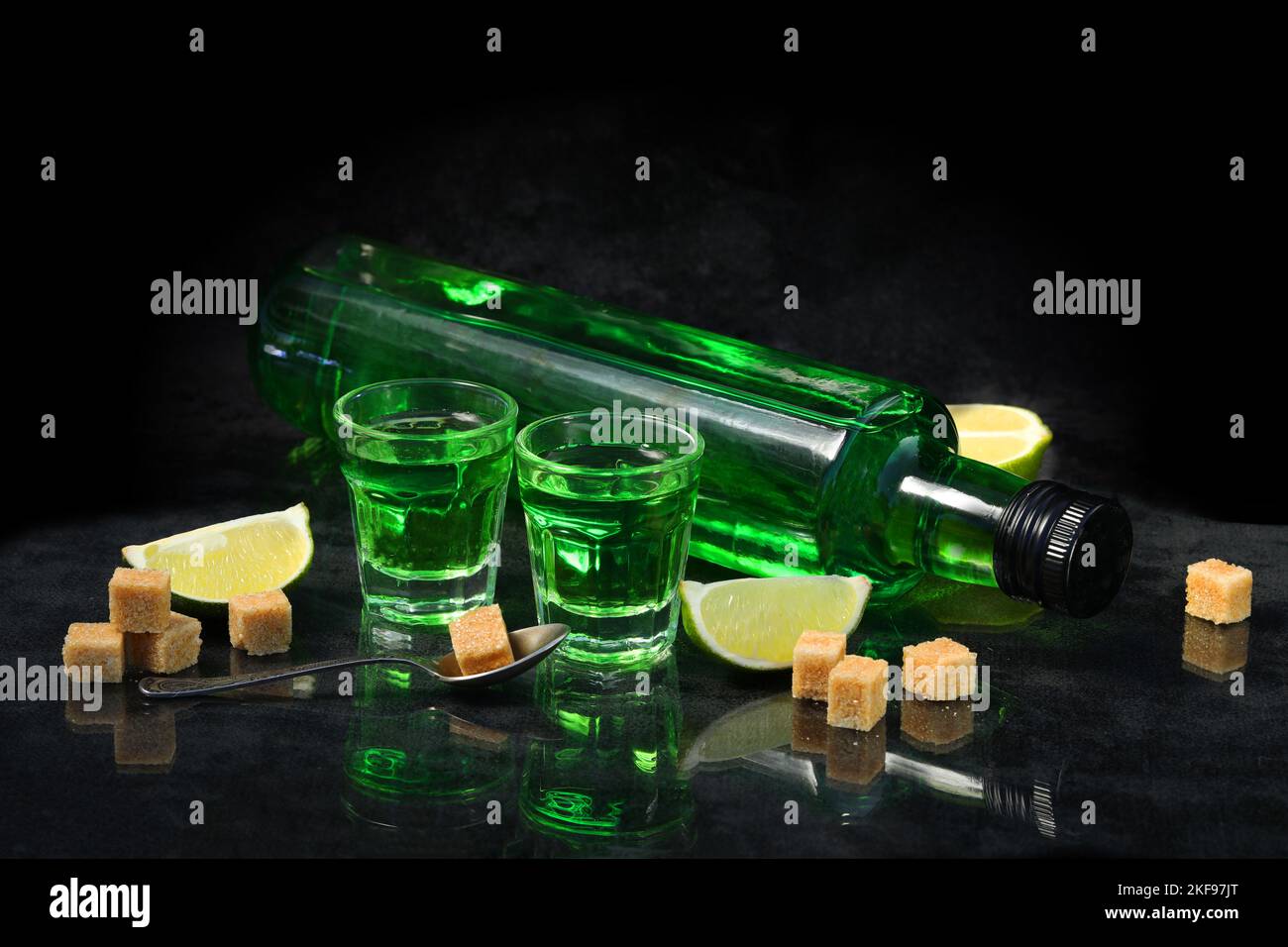 green absinthe drink on the black background with sugar and lime Stock ...