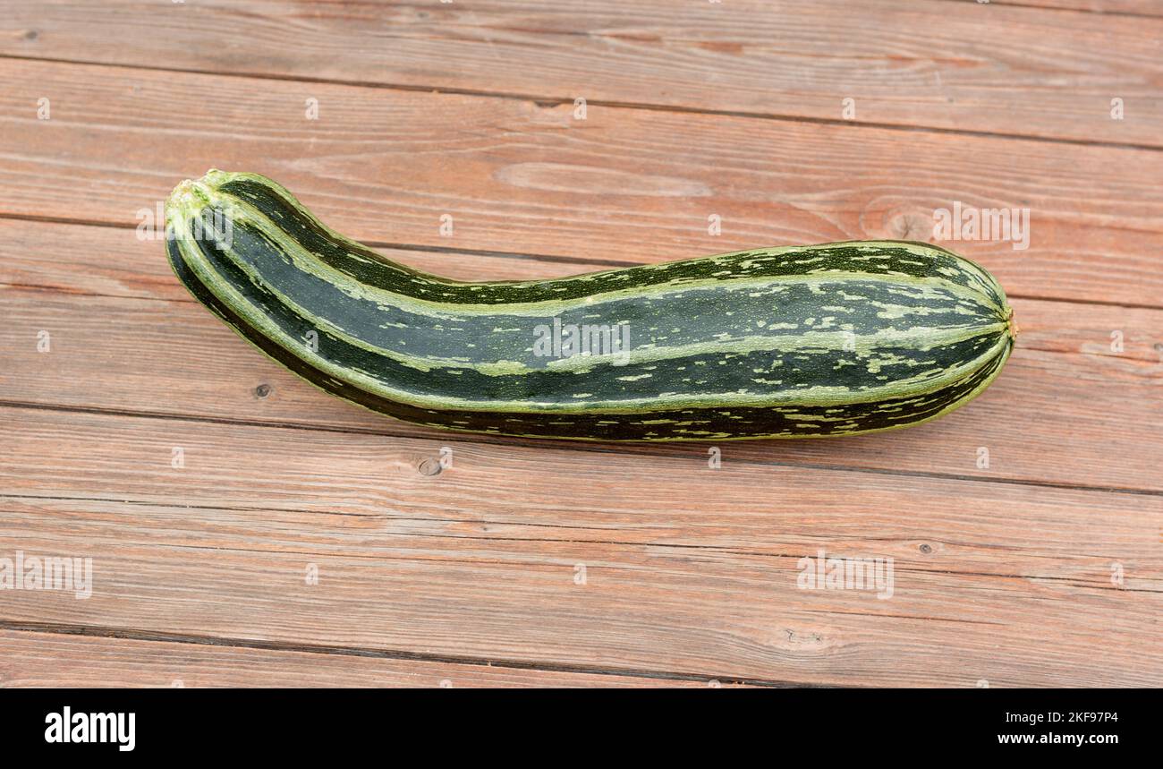 Zucchini or green courgette on a wooden table. Summer squash Stock Photo