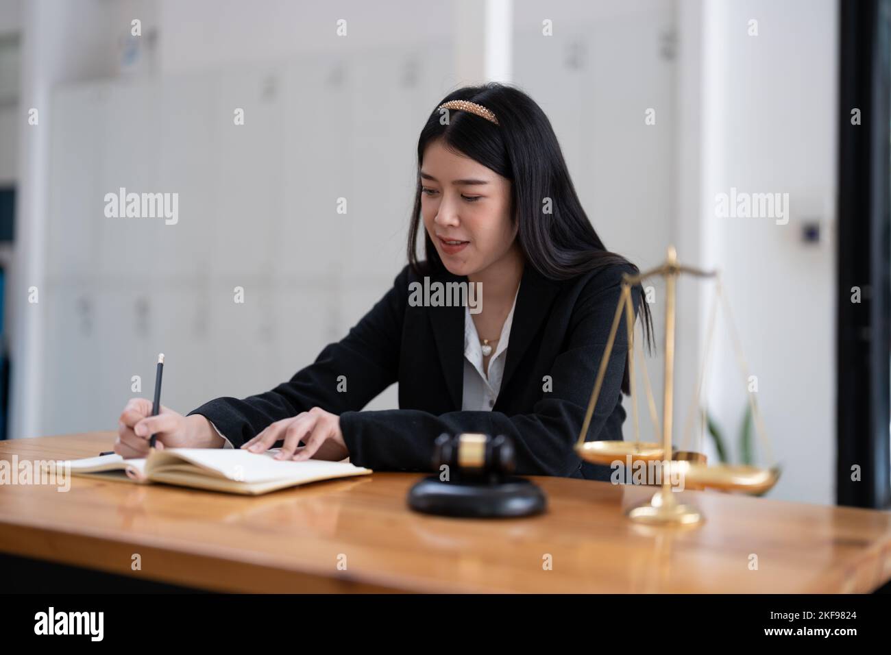 Portrait confidence asian lawyer taking note sitting at work desk in office. Stock Photo