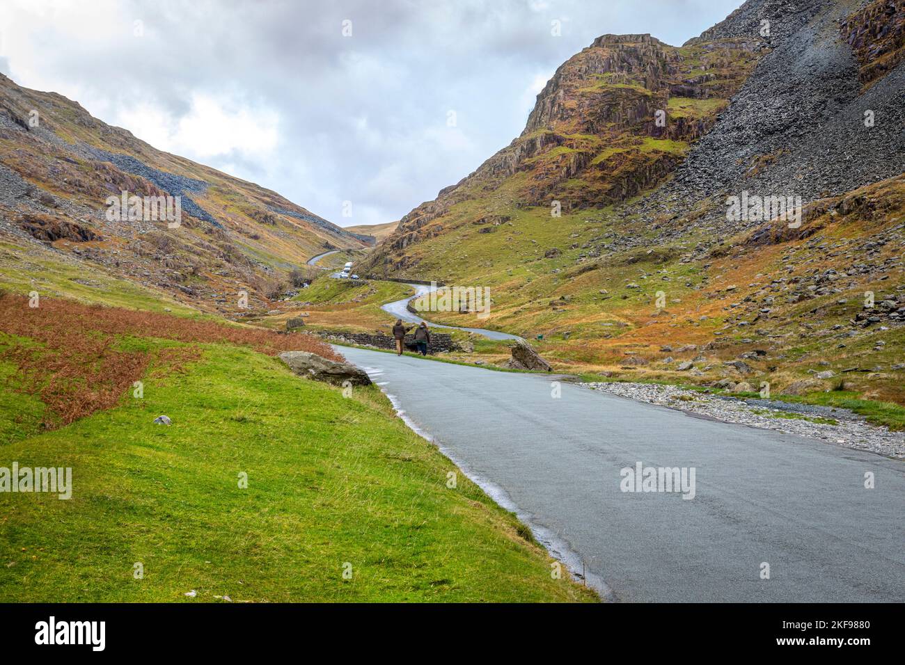People walkig and cars driving on Honnister Pass, Lake District, Cumbria. Stock Photo