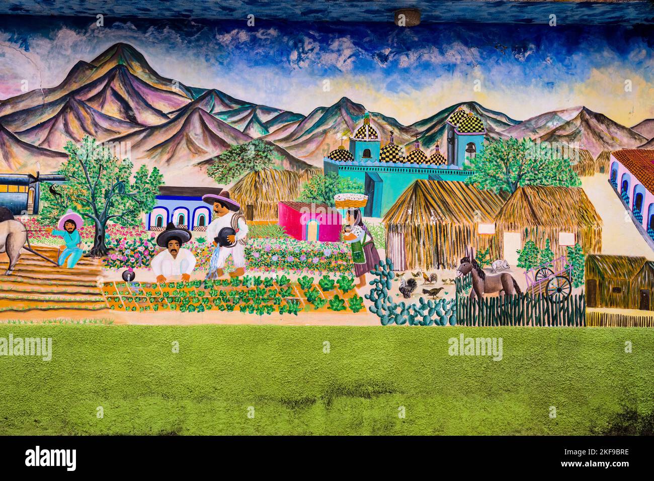 A painted mural depicting village life on the side of a house in San