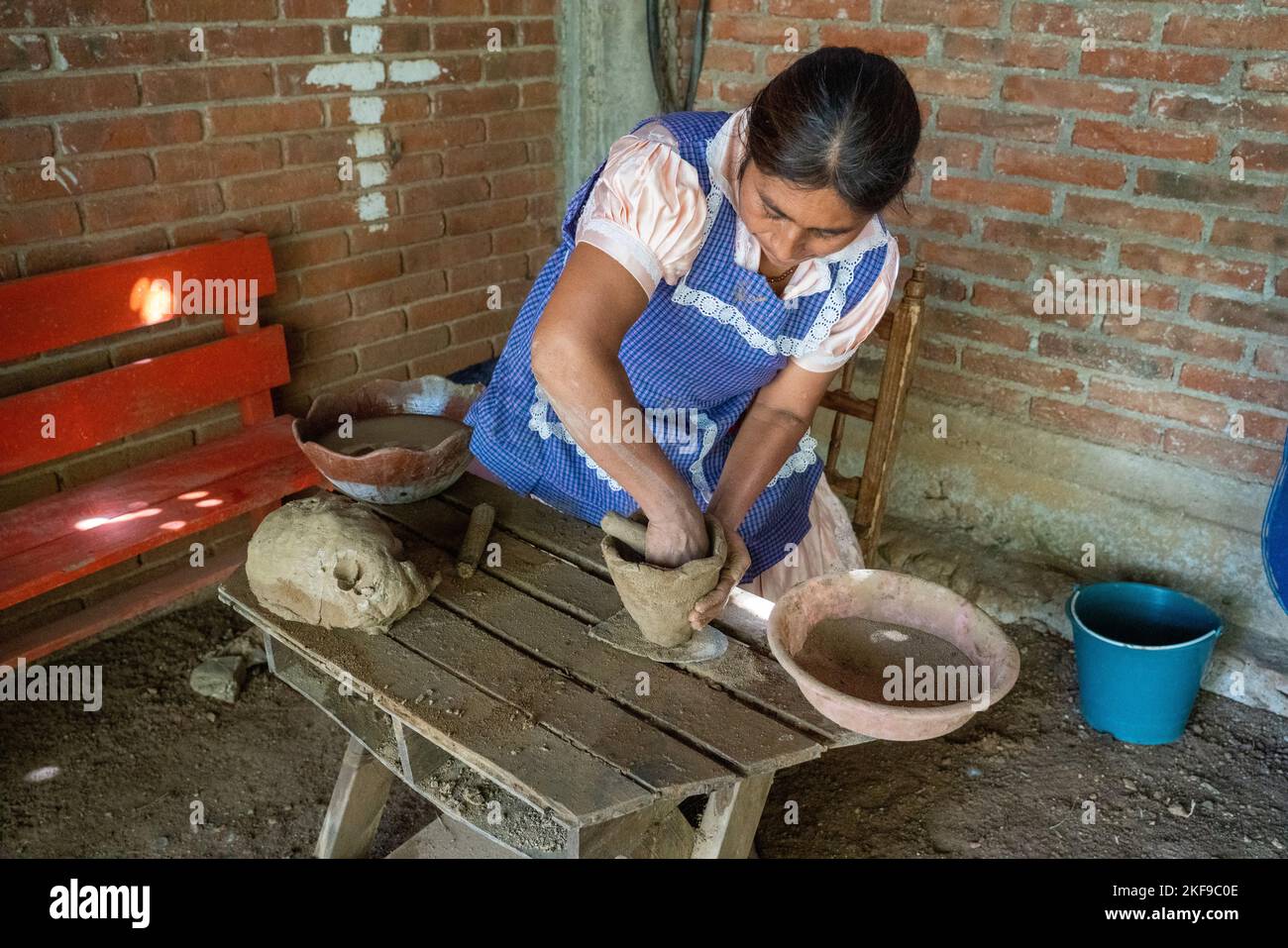 Making red clay pottery. The potter begins to shape red clay with a ...